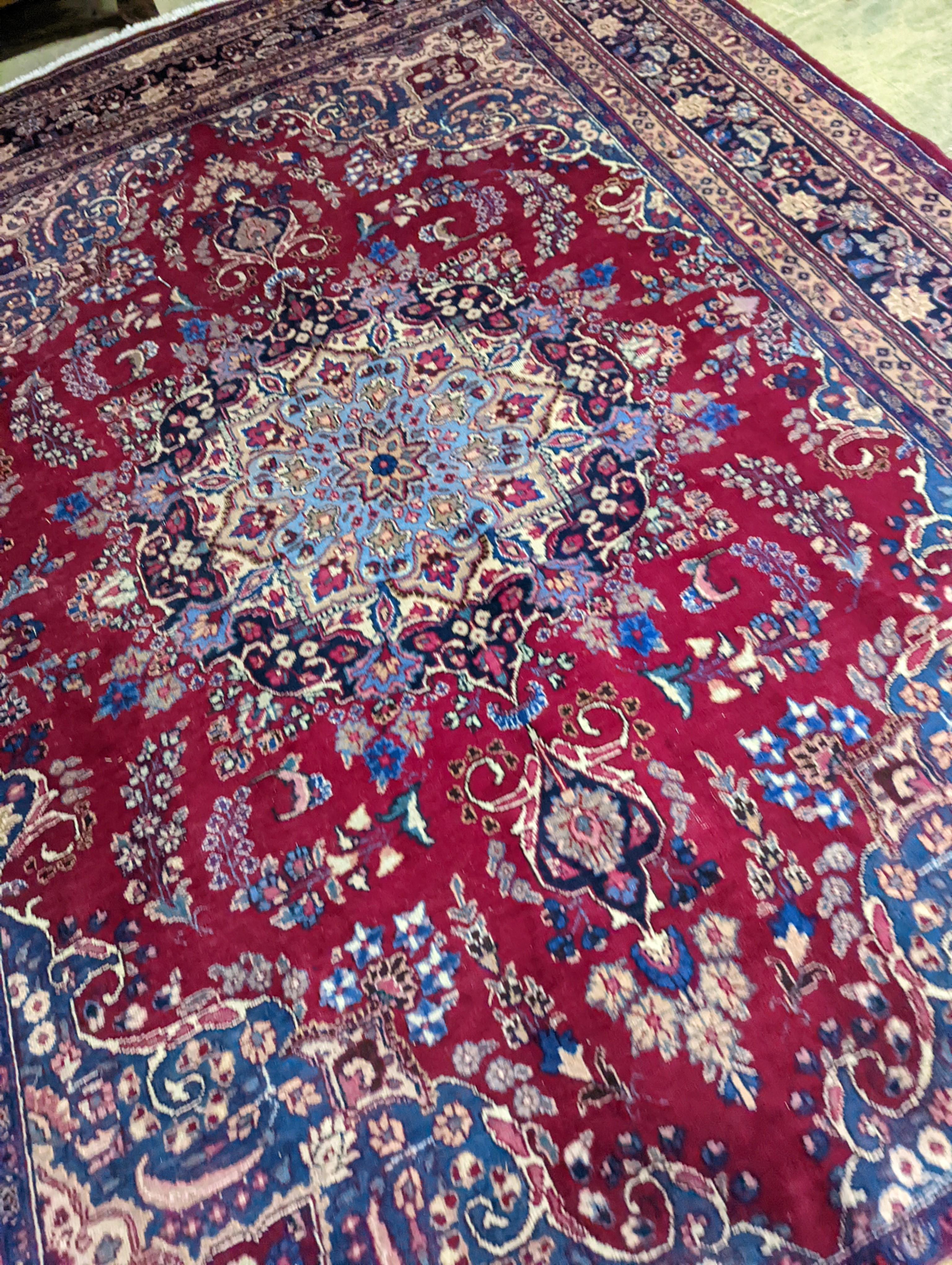 A Tabriz burgundy ground carpet, 350 x 250cm